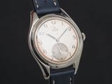 une photo d'une montre-bracelet argentée avec un bracelet en cuir bleu
