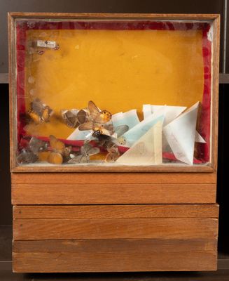 a small wooden box with a paper boat inside of it