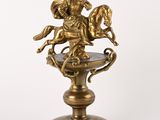 brass figurine of a man on a horse on a pedestal