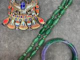 two pieces of jewelry sitting on top of a table next to each other
