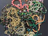 a pile of assorted beads and necklaces on a table