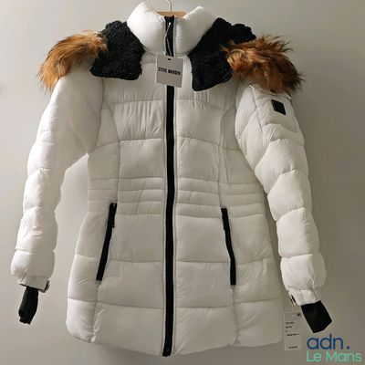 the jacket is white with black trims and a fur collar