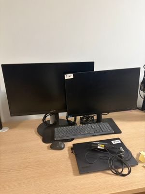 a desk with two monitors and a keyboard on it