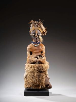une statue représentant une femme vêtue d'une robe marron et coiffée de plumes