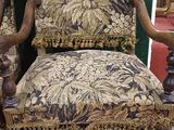a chair that has a floral upholstered back and arms