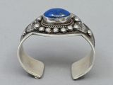 a close up of a silver ring with a blue stone on it