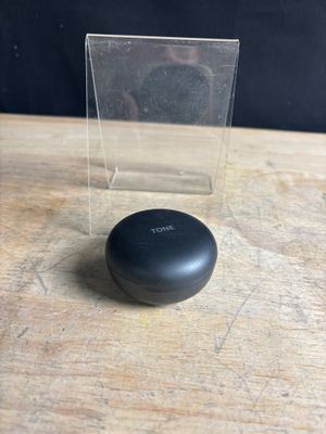un gros plan sur un petit objet noir posé sur une table en bois