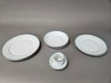four plates and a cup sitting on a table