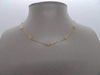 un gros plan sur un mannequin portant un collier en or