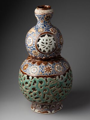 un vase bleu et vert orné d'un motif décoratif
