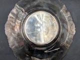 a silver plate with a silver lid on a black surface