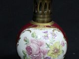 a small vase with flowers on it next to a cup and saucer