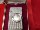an image of a silver watch in a box on a red cloth