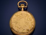 an antique gold pocket watch on a dark blue background