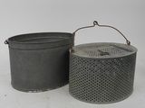 two metal buckets sitting next to each other on a white surface