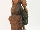 statue of a woman sitting on a rock with her hand on her knees