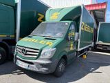 a green truck that is parked in front of a building