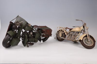 two motorcycles that are sitting side by side on a white surface
