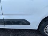 une camionnette blanche endommagée, garée sur le parking