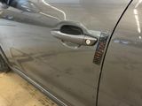 a close up of a car door handle with a sticker on it