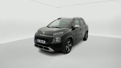 Une Citroën noire est garée dans une pièce blanche