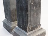 two old tombstones sitting next to each other on a white surface