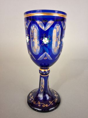 a blue glass with gold and white designs on it