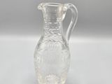 pichet en verre transparent orné d'un motif floral au fond