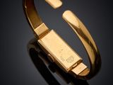 a close up of a gold bracelet on a black surface