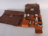 a brown leather case with a brush and other items in it