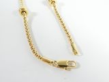 a close up of a gold chain on a white surface