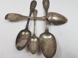 three spoons and a spoon rest on a white surface
