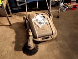 a mop that is sitting on the floor next to a trash can