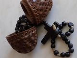 a wooden object with a cross and a rosary on a table