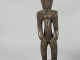 an image of a wooden statue of a man standing on a pedestal