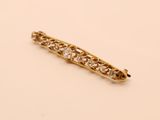 a close up of a gold and diamond hair clip on a white surface