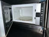 a microwave with a plate inside of it on the counter