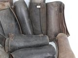 several pairs of leather boots are lined up on a white surface