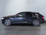 the black car is parked in a large room with a white wall