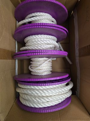 une corde violette et blanche dans une boîte en carton avec un couvercle violet