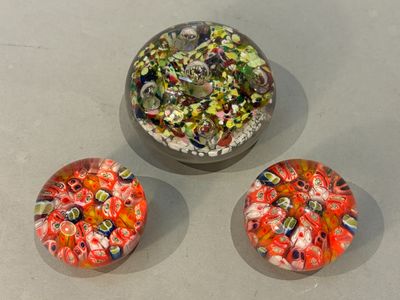 three glass bowls filled with different colored beads on top of a table