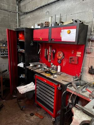 un établi rouge dans un garage, sur lequel sont posés des outils