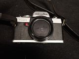 a black camera with a black strap on a black surface