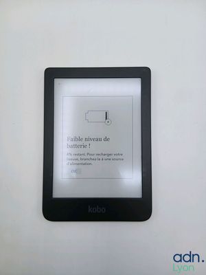 an image of a kindle sitting on top of a table next to a white wall