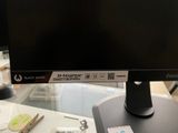 a computer monitor sitting on top of a desk next to a keyboard