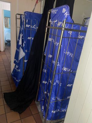 un portant métallique sur lequel sont suspendus des vêtements, dans un couloir
