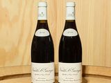 deux bouteilles de vin posées l'une à côté de l'autre sur un tonneau