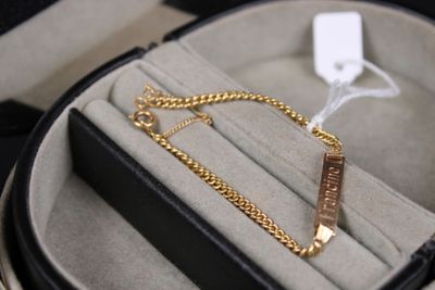 un boîtier noir avec un bracelet en or et une chaîne en or
