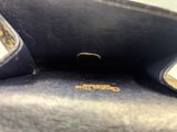 un gros plan d'un sac à main noir orné d'un logo doré