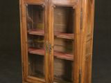 une image représentant une armoire en bois avec des portes vitrées sur fond noir